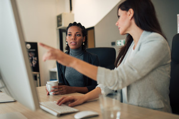 Two businesswoman discussing work results.