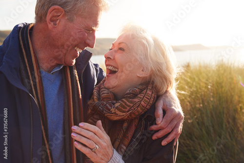 Fotografía Loving Active Senior Couple Hugging As They Walk Through Sand Dunes