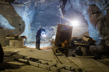 Wall Mural - Underground gold mine miners repairs the wagon