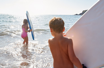 Wall Mural - Children Playing In Sea With Bodyboards On Summer Beach Vacation