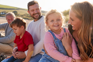 Wall Mural - Family With Grandfather Relaxing On Beach With Flaring Sun