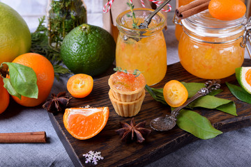 Wall Mural - Citrus jam of kumquats and two sorts of mandarins with thyme and anise served in shortbread tartlets on dark wooden board