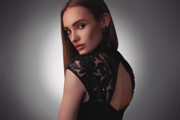 Sexy young lady in black dress in studio