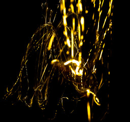 Wall Mural - abstract texture of Golden sparkles on a black background, Golden highlights in the form of spirals and iridescence