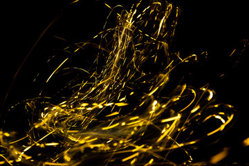 Wall Mural - abstract texture of Golden sparkles on a black background, Golden highlights in the form of spirals and iridescence
