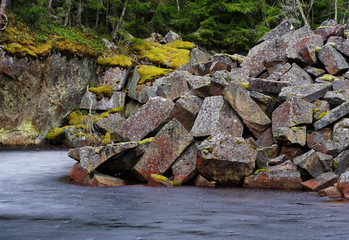 Colorful stone blocks in an old derelict quarry, filled with water