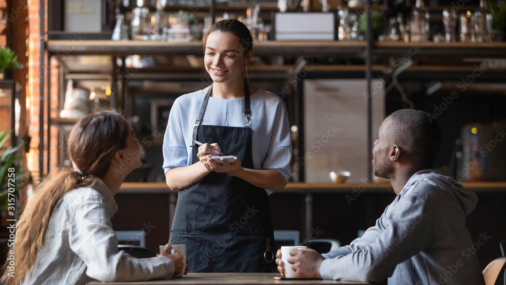 Smiling waitress taking order from multiracial clients - obrazy, fototapety, plakaty 