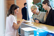© Westend61 - Two smiling businesswomen talking to woman at reception desk