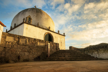 Canvas Print - Socorro Chapel in Vila do Conde, Portugal, lit by the sunset and a sky with clouds in the background.