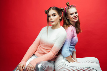 two best friends teenage girls together having fun, posing emotional on red background, lifestyle people concept