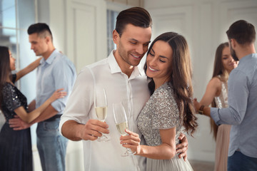 Canvas Print - Lovely young couple with glasses of champagne at dancing party