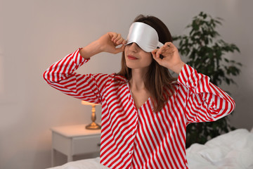 Sticker - Beautiful woman wearing pajamas and sleep mask indoors. Bedtime