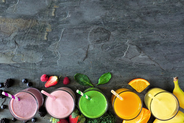 Poster - Assorted healthy fruit smoothies in. Top view bottom border against a dark background. Copy space.