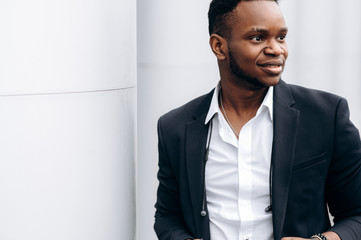 Wall Mural - Attractive african american man in stylish formal suit looks away, outdoors