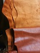 Different pieces of leather in a rolls. The pieces of the colored leathers. Raw materials for manufacture of bags, shoes, clothing and accessories.