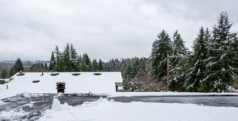 Fresh wet snow on a flat carport roof, no people, residential neighborhood