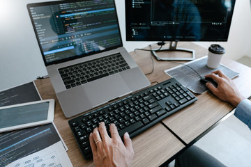 Wall Mural - programmer typing code on desktop computer, developing programming and coding technologies concept.