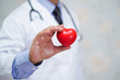 © amazing studio - Doctor holding red heart in his hand in nursing hospital ward : healthy strong medical concept .