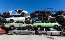 Old Damaged Cars On The Junkyard Waiting For Recycling