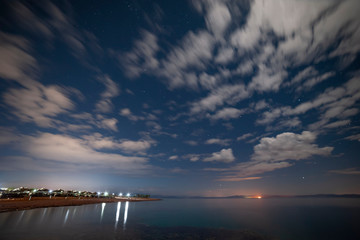 Wall Mural - many stars and clouds over ocean