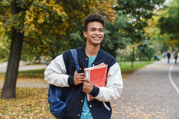 Cheerful african boy teenager walking at the park