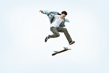 caucasian young skateboarder riding isolated on a white studio background. man in casual clothing tr