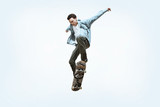 Caucasian young skateboarder riding isolated on a white studio background. Man in casual clothing training, jumping, practicing in motion. Concept of hobby, healthy lifestyle, youth, action, movement.