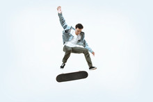 Caucasian Young Skateboarder Riding Isolated On A White Studio Background. Man In Casual Clothing Training, Jumping, Practicing In Motion. Concept Of Hobby, Healthy Lifestyle, Youth, Action, Movement.