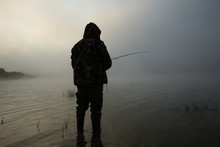 Silhouette Of Fisherman In Fog With Copy Space