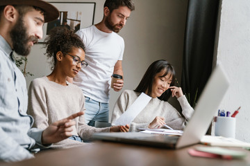 Image of multiethnic young business people working together at office