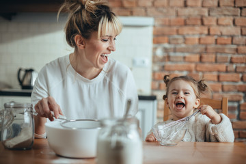 Mother and daughter baking cookies in their kitchen