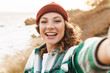 © Drobot Dean - Image of caucasian woman taking selfie photo while walking outdoors