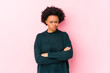 © Asier - Middle aged african american woman against a pink background isolated frowning face in displeasure, keeps arms folded.