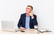 © Asier - Young business man with a laptop showing a mobile phone call gesture with fingers.