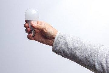 Energy saving light bulb in the hand of an adult