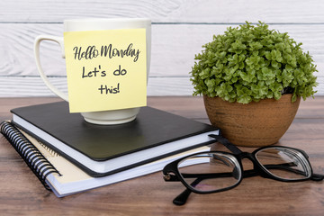 inspirational quotes - hello monday, let's do this text on sticky note on top of table