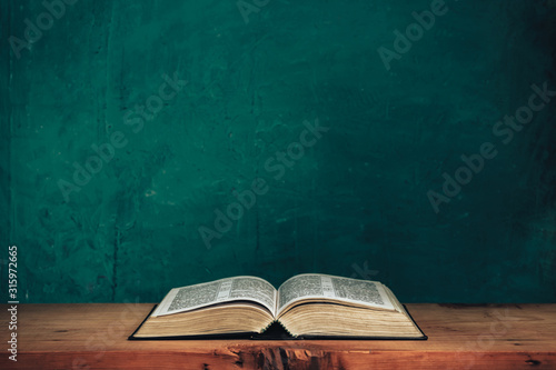 Fotomural Open bible on a red old wooden table