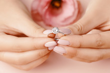 Close Up Of Woman's Hand Holding Elegant Diamond Ring.