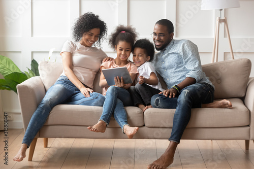 Fotografía Happy african american family using tablet together.