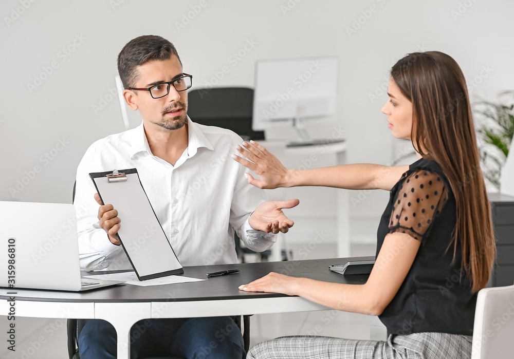 Bank manager working with displeased woman in office