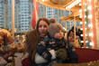 © MadCat13Shoombrat - Mother and child on the carousel. Vintage carousel. The winter fair. Christmas fair. Happy family.