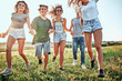 © HBS - Big group of happy friends run and jump at sunset field against sunshine