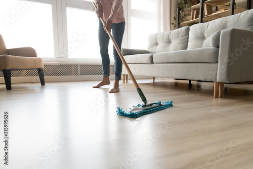Cuadros en Lienzo Barefoot woman cleaning floor with wet mop pad cropped image.