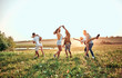 © HBS - group of happy young people dancing on the field on beautiful summer sunset