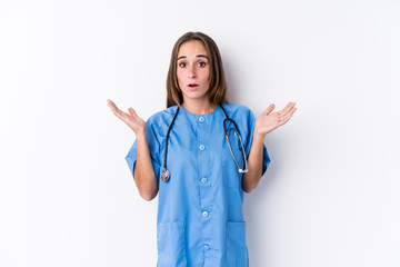 Wall Mural - Young nurse woman isolated surprised and shocked.