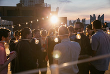 String Lights Over Crowd At Rooftop Party