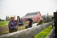 Ranchers With Fence Posts Talking In Pasture