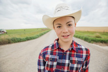 Portrait Of Boy In Cowboy Hat On Road
