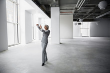 Businesswoman Envisioning With Finger Frame In Empty Office