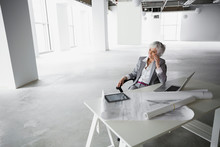 Architect Talking On Cell Phone In Empty Office